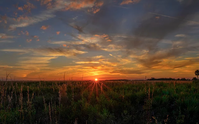 A brilliant sunset illuminates the dramatic sky at Kissimmee Prairie Preserve in Okeechobee, FL – Florida, cheap car insurance in Kissimmee