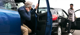 Male drivers, both older and younger, get out of their cars and inspect the damage after a traffic accident — cheap bodily injury liability insurance.