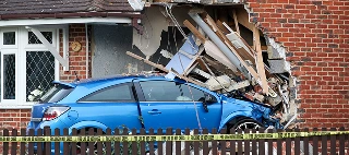 Blue car leaves the road and crashes into a house — cheap property damage liability insurance.