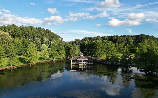 Aerial view of a lake in a forested landscape in Florence, Alabama. Cheap car insurance in Alabama.