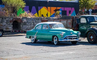A classic car and truck parked in the Marietta Square in front of colorful wall mural in Marietta, Georgia, USA – Marietta, cheap car insurance in Georgia