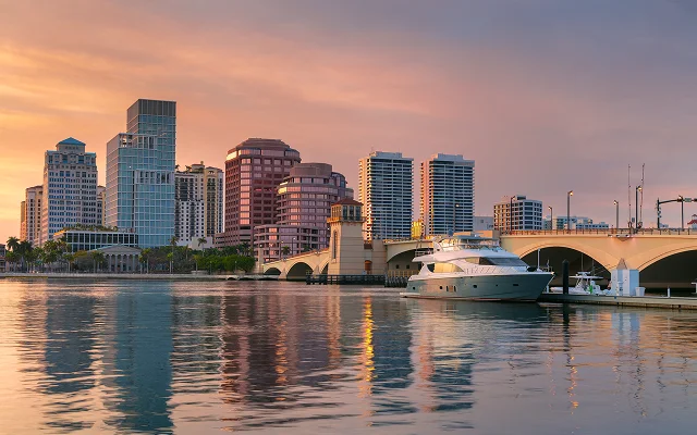Cityscape image of West Palm Beach, Florida with reflection of the city skyline in the water at beautiful sunset – West Palm Beach, cheap car insurance in Florida