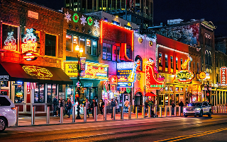 Nashville, TN, USA - 12-24-2023: Famous Neon signs of blues clubs on Beale street illuminated at night in downtown Nashville city attraction – Nashville, cheap car insurance in Tennessee